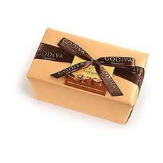 Le ballotin Belge classique et élégant est enveloppé dun luxueux papier doré rehaussé dun ruban noué à la main et garni dun somptueux assortiment de chocolats de qualité Godiva.