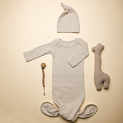 Bienvenue au nouveau bébé avec cet ensemble-cadeau pour bébé Mushie! Il comprend une barboteuse en coton biologique avec des boutons et un bonnet assorti, un porte-tétine en silicone et un charmant hochet girafe en coton biologique de Trixie.