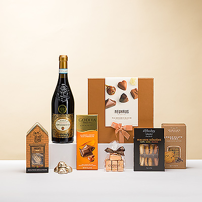 Les délices d'un vin italien rouge rubis et de chocolats belges et autres douceurs sont combinés dans ce cadeau élégant. Le vin Dezzani 'Appassimento' Rosso se déguste avec de luxueux pralinés au chocolat belge Neuhaus, des Noisettines Godiva, des biscuits au chocolat et des biscuits pralinés, des Ferrero Rocher, de riches macarons et bien d'autres choses encore.