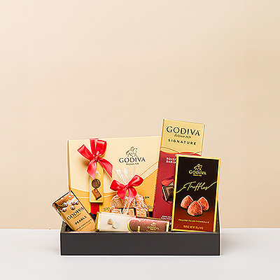 Voici un élégant cadeau de Noël pour ceux qui ont un goût irréprochable : un plateau cadeau élégant contenant de luxueux chocolats Godiva.