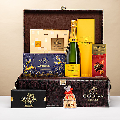 Un magnifique paquet cadeau Godiva avec logo croco comprenant une délicieuse collection de luxueux chocolats Godiva et le célèbre champagne Veuve Clicquot. Cet impressionnant cadeau de champagne et de chocolat est la manière la plus douce de célébrer Noël, le Nouvel An et les grandes réussites professionnelles.