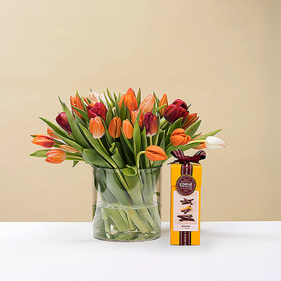 Montrez votre affection ce printemps avec un magnifique bouquet frais de tulipes colorées. Ce bouquet spécial est présenté avec une boîte d'orangettes au chocolat Corné Port-Royal. La combinaison de belles tulipes et de chocolat gratuit est le cadeau idéal pour votre famille, vos amis proches ou votre proche.