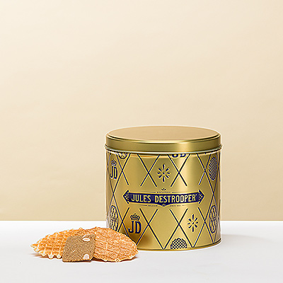 Een goudkleurige ronde geschenkblik gevuld met overheerlijke Jules Destrooper koekjes: 
amandelkoekjes, roomboterkoekjes en roomboterwafels.