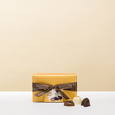 Le ballotin Belge classique et élégant est enveloppé d5un luxueux papier doré rehaussé d5un ruban noué à la main et garni d5un somptueux assortiment de chocolats de qualité Godiva.